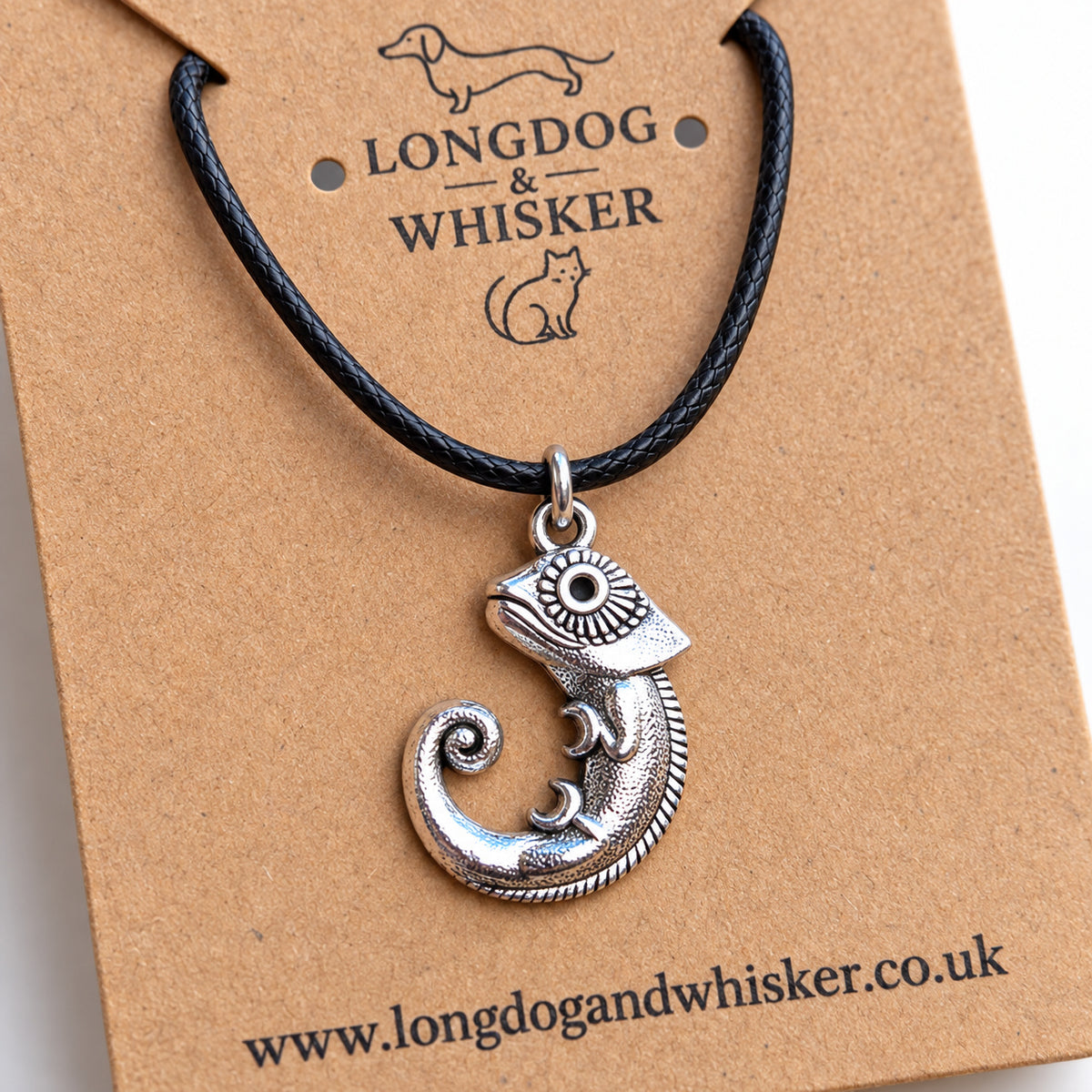 Close-up of the chameleon pendant's patterned eye, curled legs and spiral tail