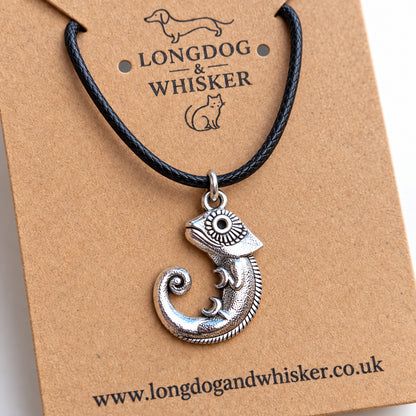 Close-up of the chameleon pendant's patterned eye, curled legs and spiral tail