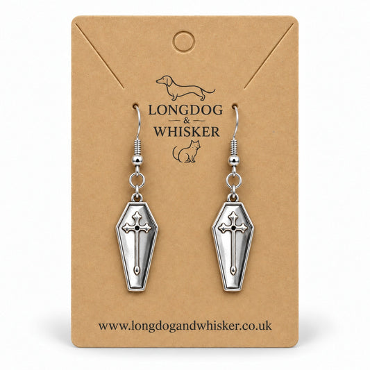 Silver coffin cross drop earrings on a Longdog & Whisker kraft card.