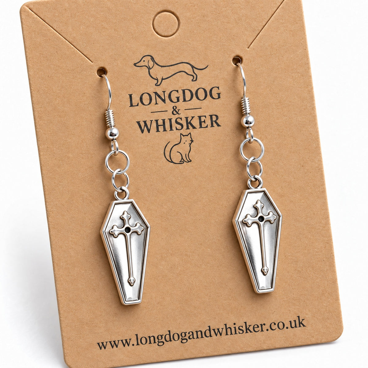 Close-up of silver coffin earrings showing the raised crosses and fishhook fittings.