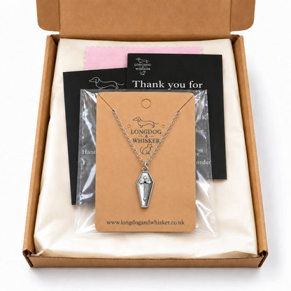 Silver coffin cross necklace on its card in Longdog & Whisker postal packaging.