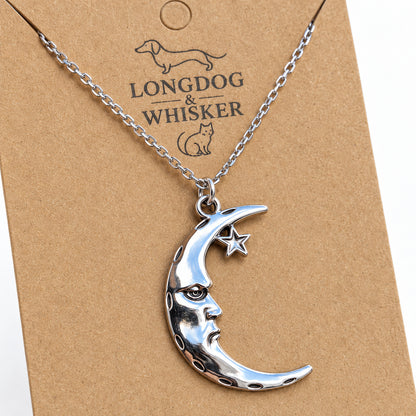 Close-up of the reflective crescent moon face, fixed star and silver-tone chain