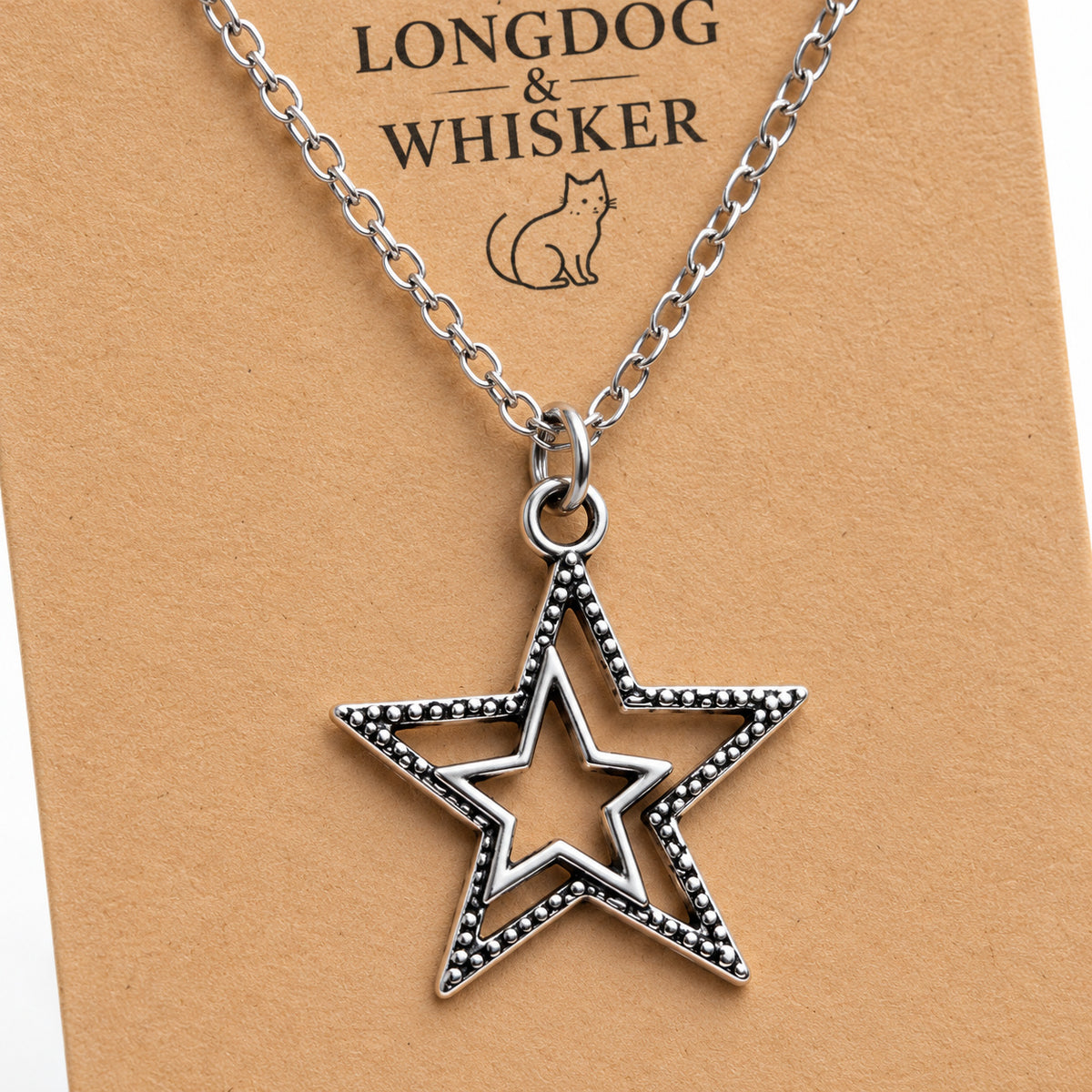 Close-up of the silver double star pendant, dotted edging and chain connectors.