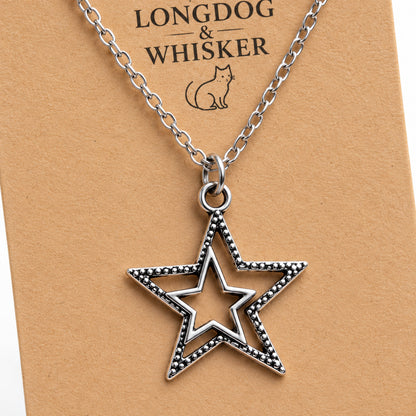 Close-up of the silver double star pendant, dotted edging and chain connectors.