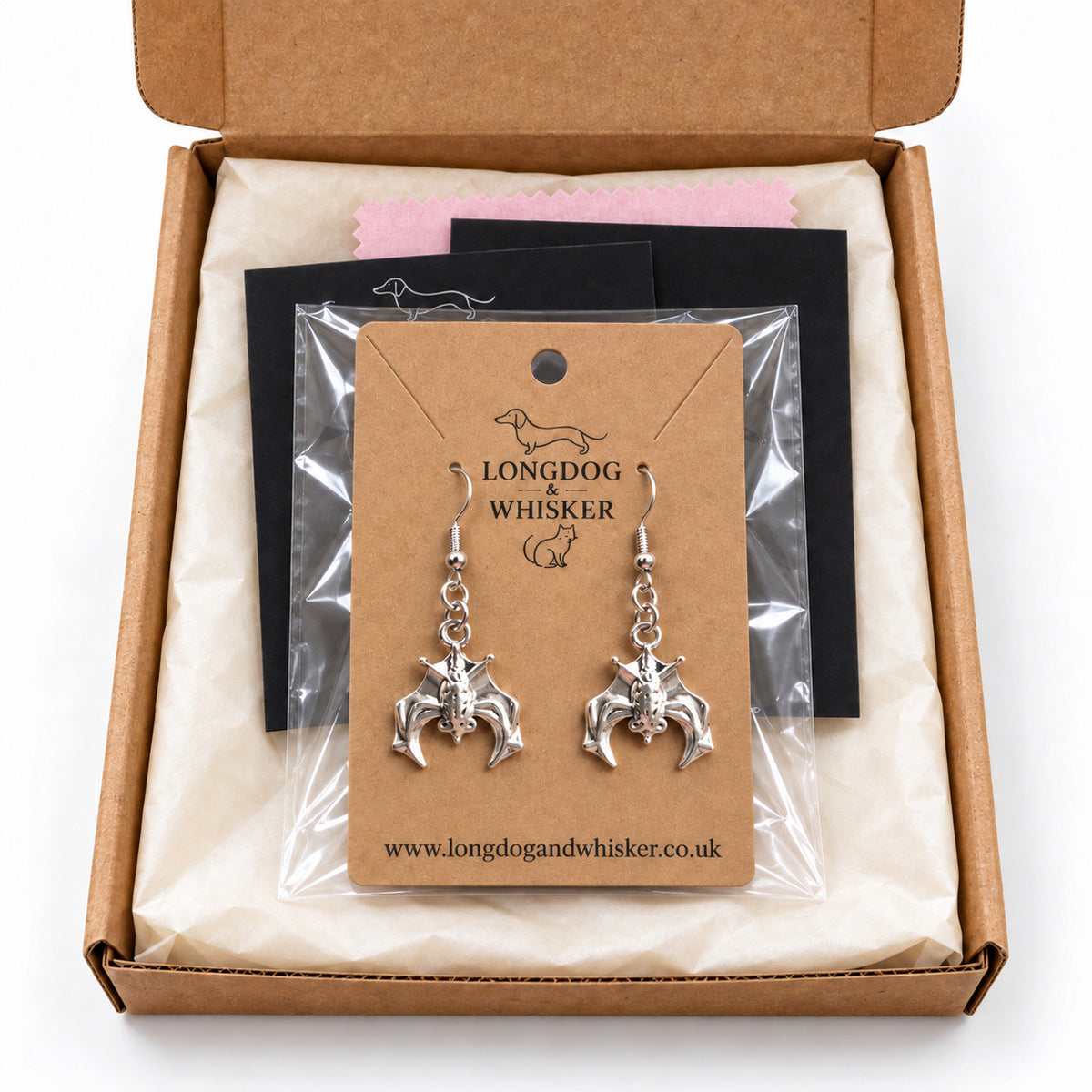 Silver hanging bat earrings presented in Longdog & Whisker packaging