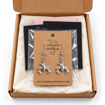 Silver hanging bat earrings presented in Longdog & Whisker packaging