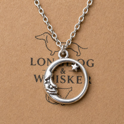 Close-up of silver crescent moon and star necklace pendant