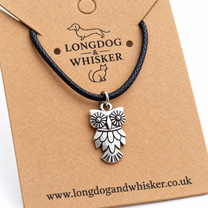 Close-up of the owl pendant's patterned eyes, feather detail and black cord connector