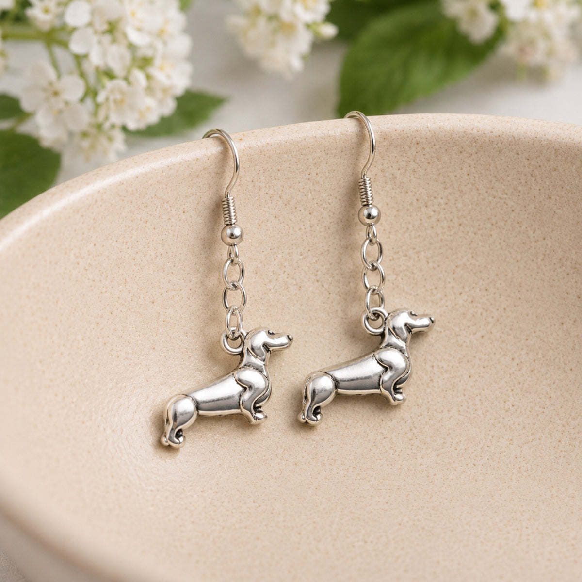 Sausage Dog Earrings - Brushed Silver displayed in a lifestyle product photo