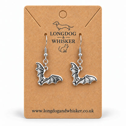 Silver-tone scalloped wing bat drop earrings on a Longdog & Whisker kraft card