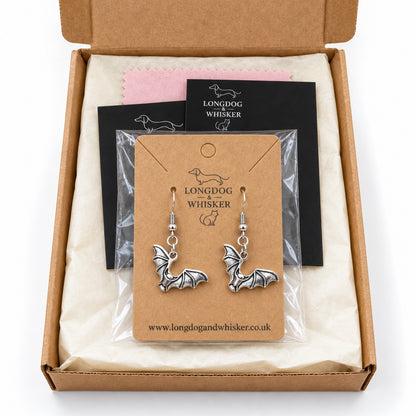 Silver-tone scalloped wing bat earrings on their kraft card in Longdog & Whisker packaging