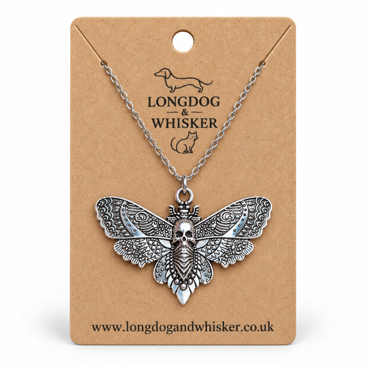 Silver-tone skull moth necklace on a silver chain, displayed on a Longdog & Whisker kraft card
