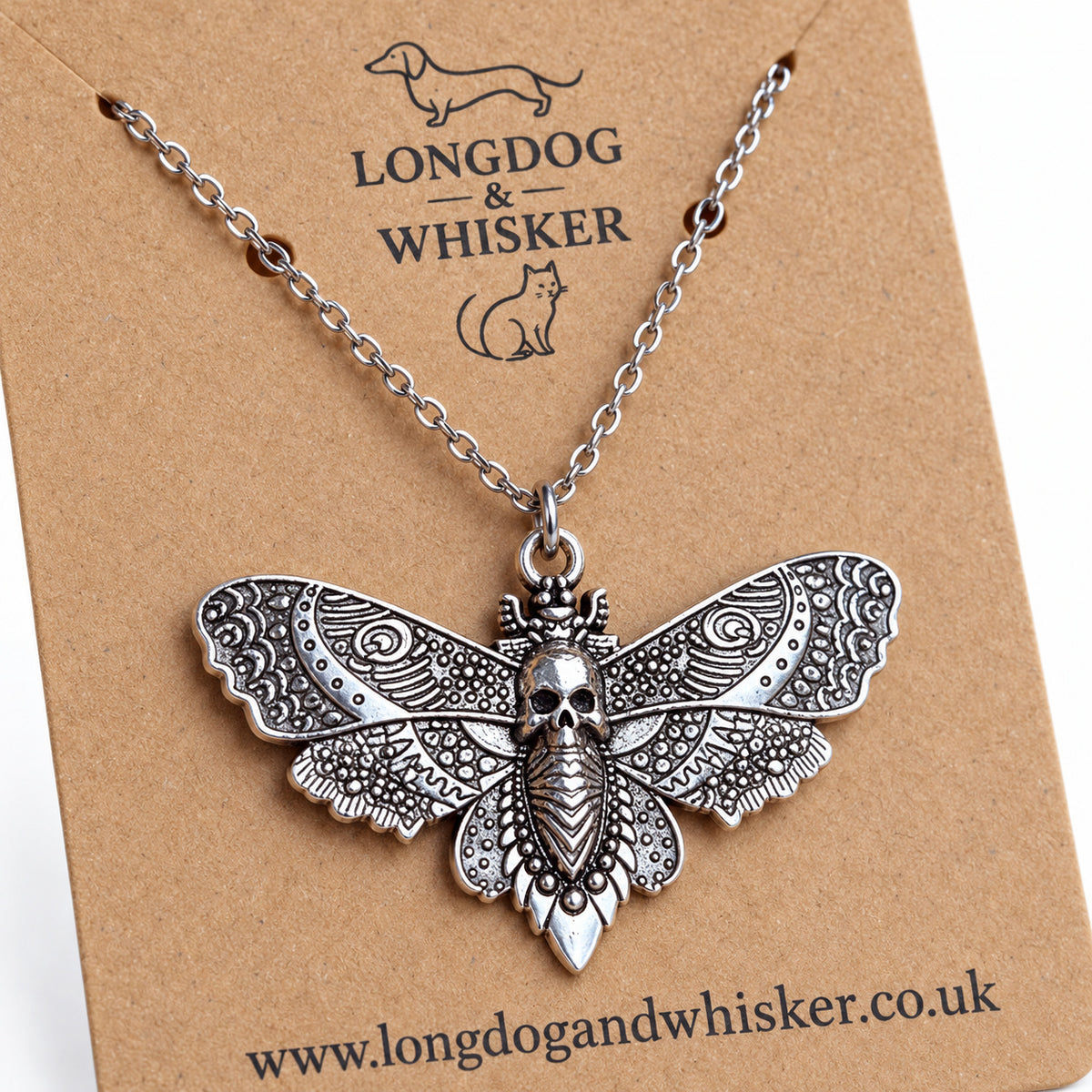 Close-up of the skull and ornate wing details on the silver-tone moth pendant