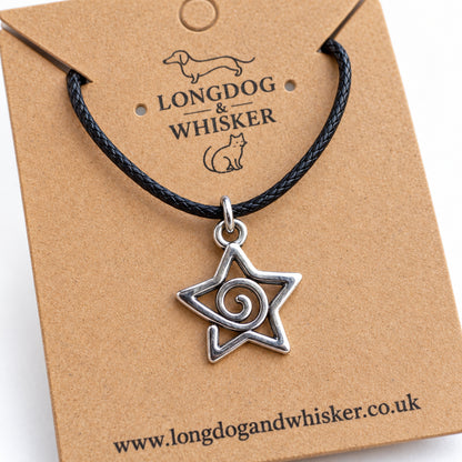 Close-up of the spiral star pendant's open outline, curling centre and black cord connector
