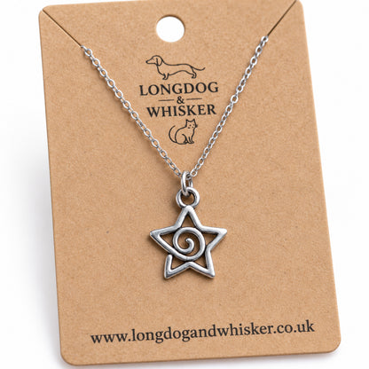 Close-up of the spiral star pendant's open outline, curling centre and chain connector