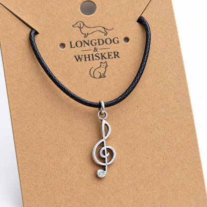 Close-up of the silver-tone treble clef pendant and black cord connectors