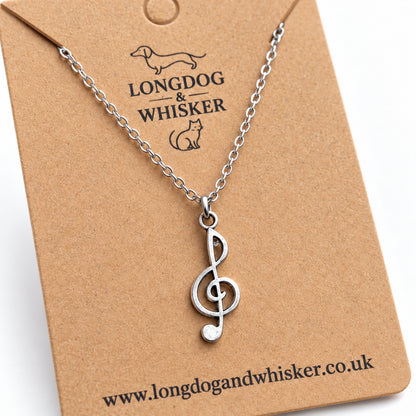 Close-up of the silver-tone treble clef pendant and link chain connectors