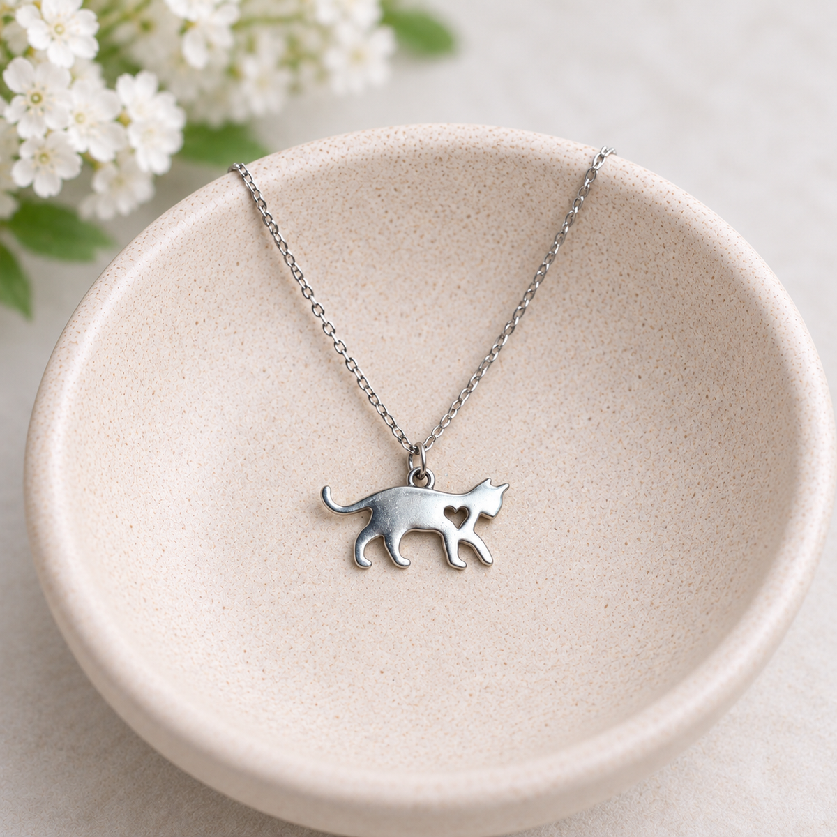 Silver Walking Cat Necklace styled in a ceramic bowl