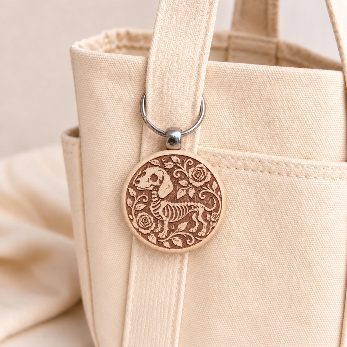 Skeleton Sausage Dog wooden keyring attached to a cream tote bag