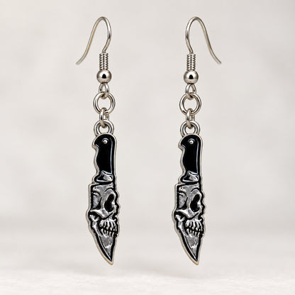 Close-up of the skull detail, black handles and pointed blades on the earrings