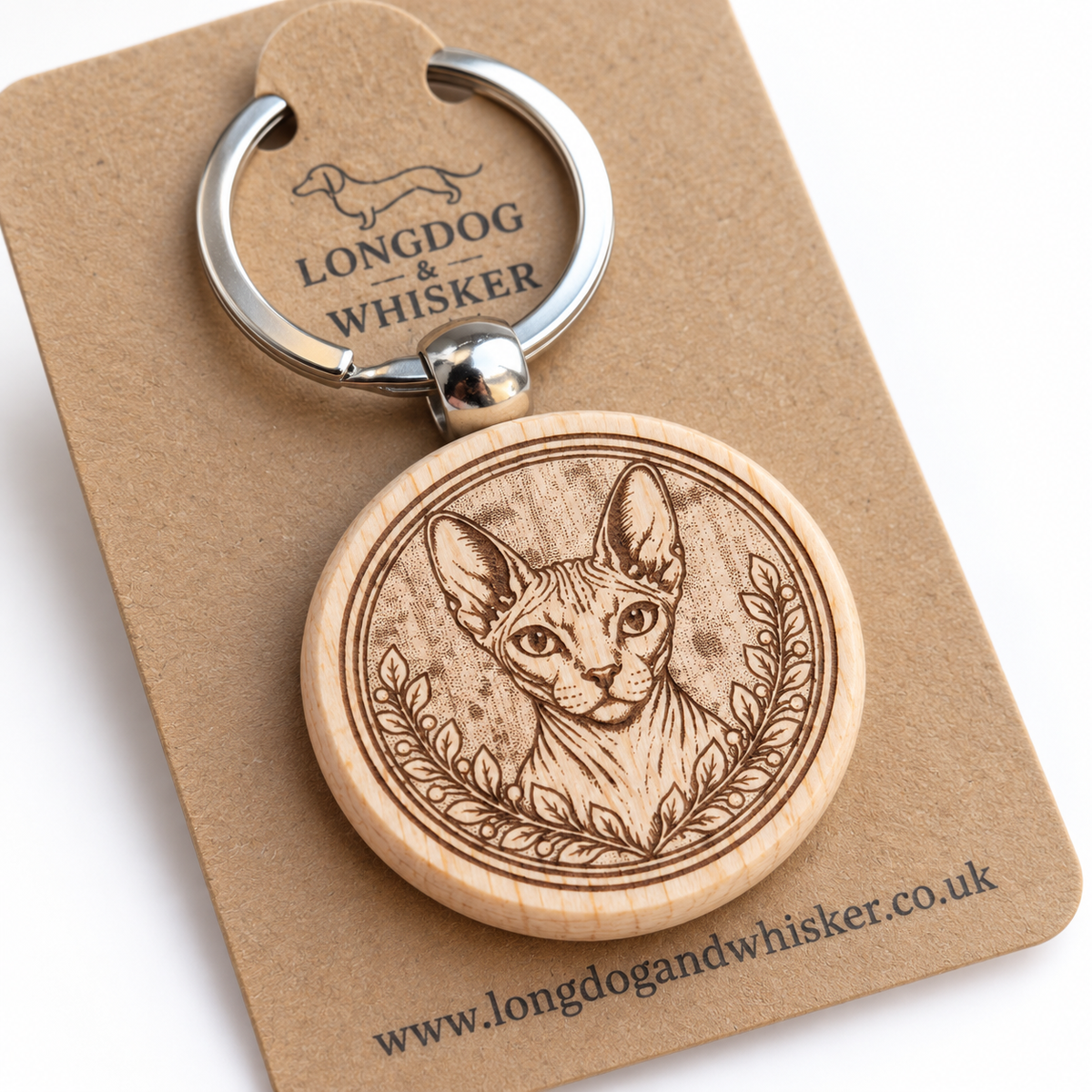 Close-up of Sphynx cat portrait engraving, leafy frame and rounded wooden keyring edge