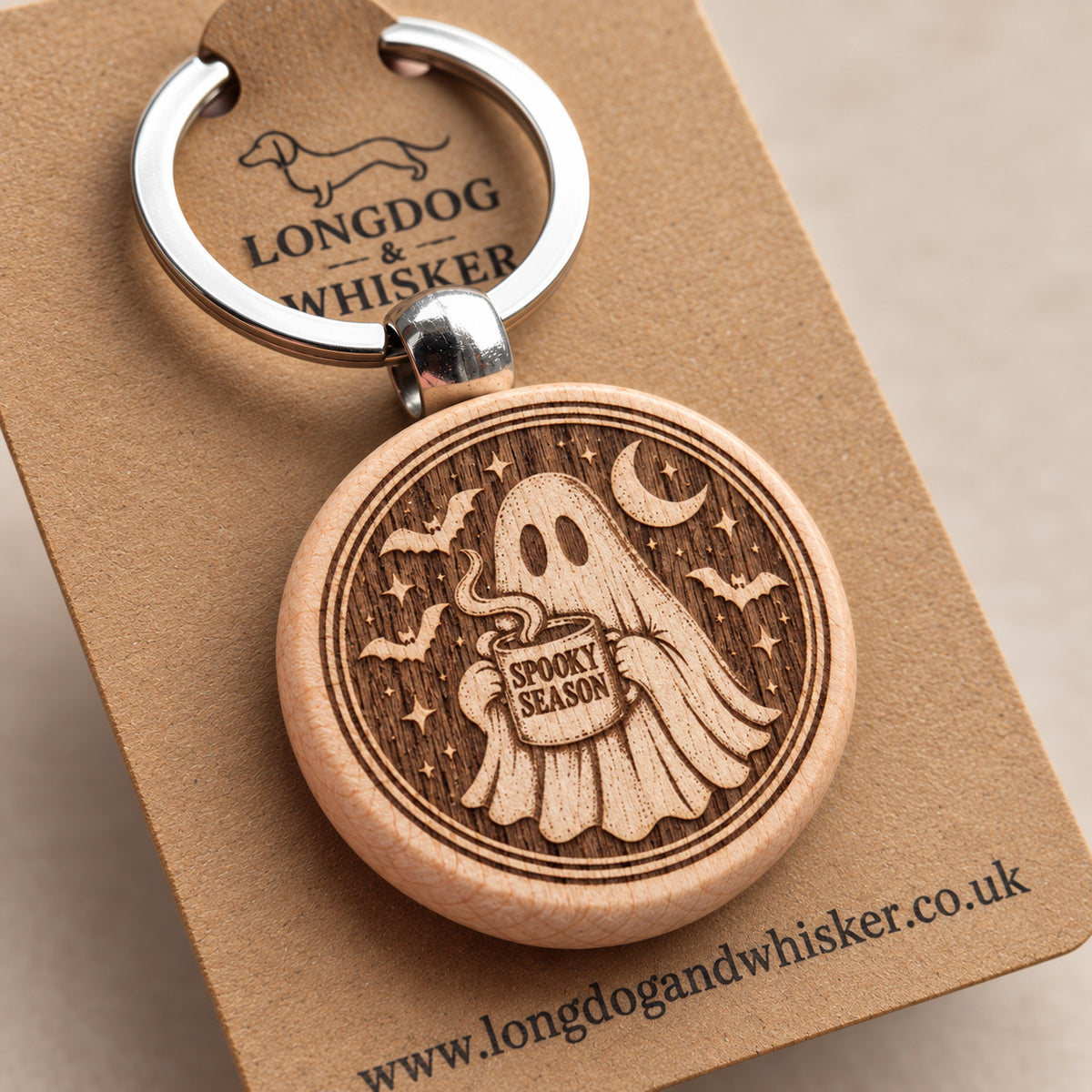 Close-up of Spooky Season ghost engraving on round wooden keyring