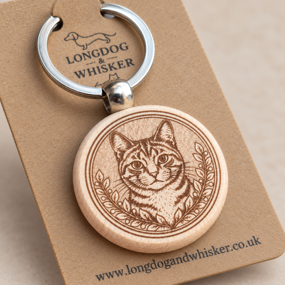 Close-up of tabby cat stripes, leafy engraving and rounded wooden keyring edge