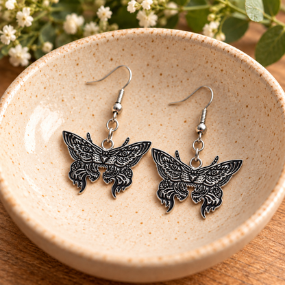 Silver Tiger Moth Drop Earrings in a speckled ceramic bowl