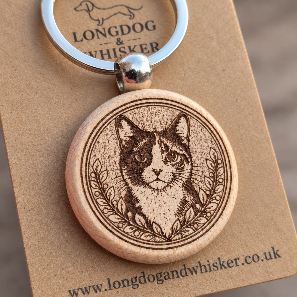 Close-up of the tortoiseshell cat portrait, leafy border, rounded wooden edge and silver-tone connector