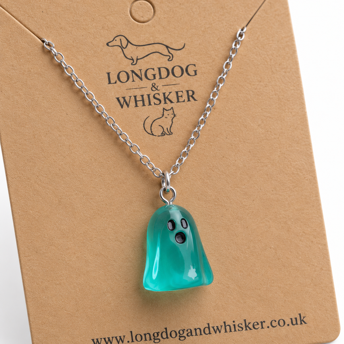Close-up of the translucent aqua ghost pendant, black face and silver connecting rings.