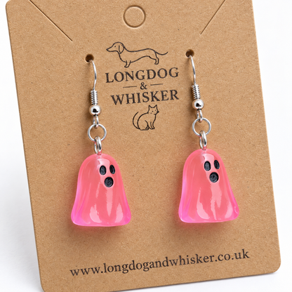 Close-up of translucent bright pink ghost earrings and silver-coloured hooks