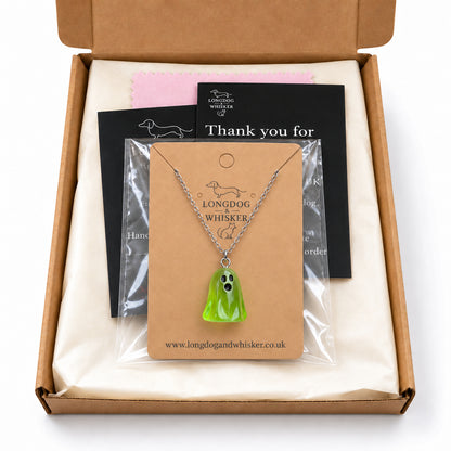 Translucent green ghost necklace on its card in Longdog & Whisker postal packaging.