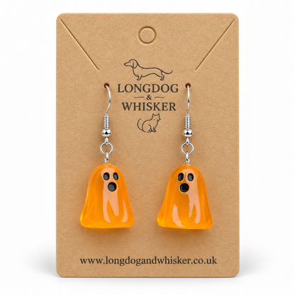 Translucent orange ghost earrings with silver hooks on a Longdog & Whisker kraft card