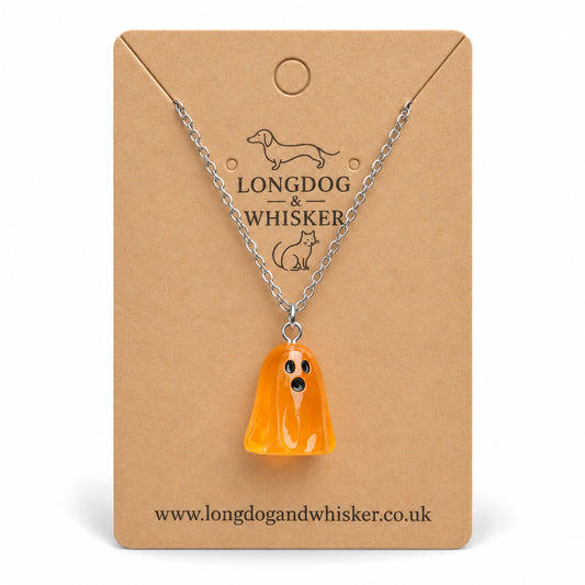 Translucent orange ghost necklace with silver chain on a Longdog & Whisker kraft card.
