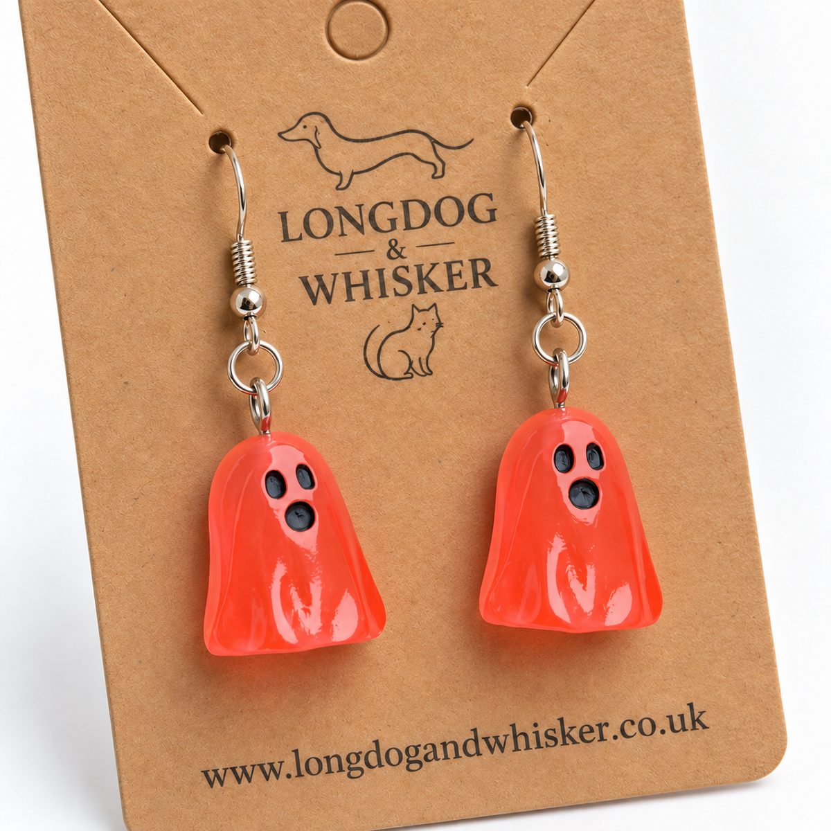 Close-up of translucent pale red ghost earrings and silver-coloured hooks