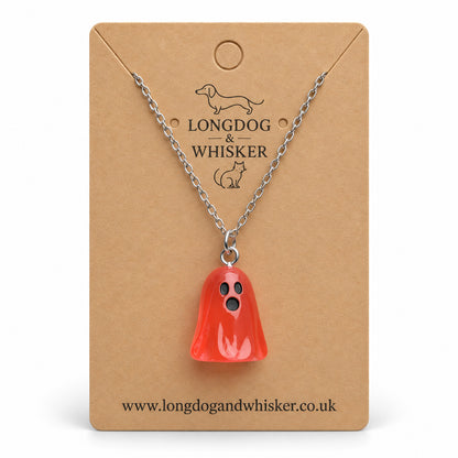Translucent pale red ghost necklace with silver chain on a Longdog & Whisker kraft card.