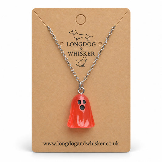 Translucent pale red ghost necklace with silver chain on a Longdog & Whisker kraft card.