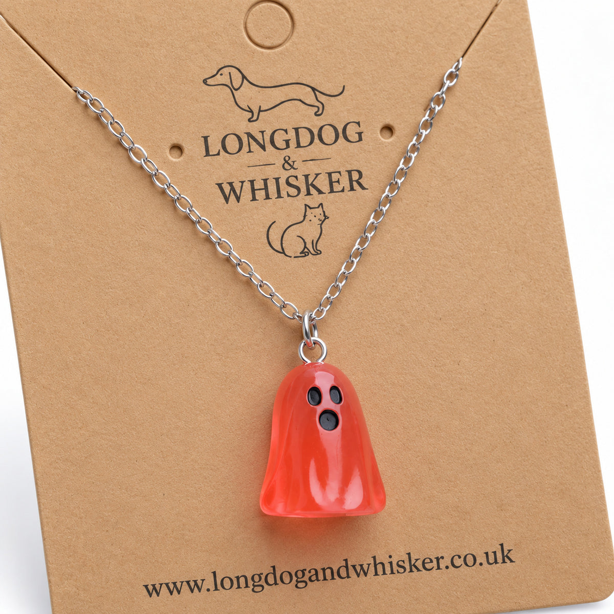 Close-up of the translucent pale red ghost pendant and silver connecting rings.