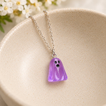 Translucent purple ghost necklace resting in a speckled ceramic bowl.