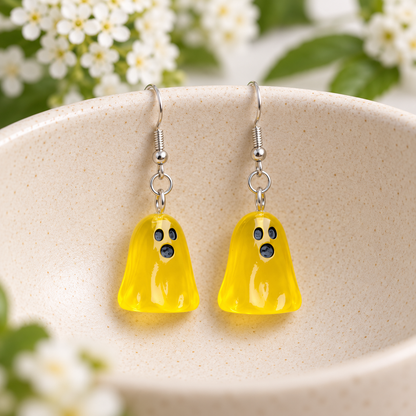 Translucent yellow ghost earrings displayed in a cream ceramic bowl