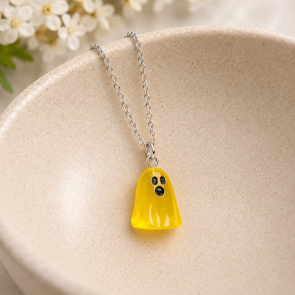 Translucent yellow ghost necklace resting in a speckled ceramic bowl.