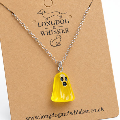 Close-up of the translucent yellow ghost pendant and silver connecting rings.