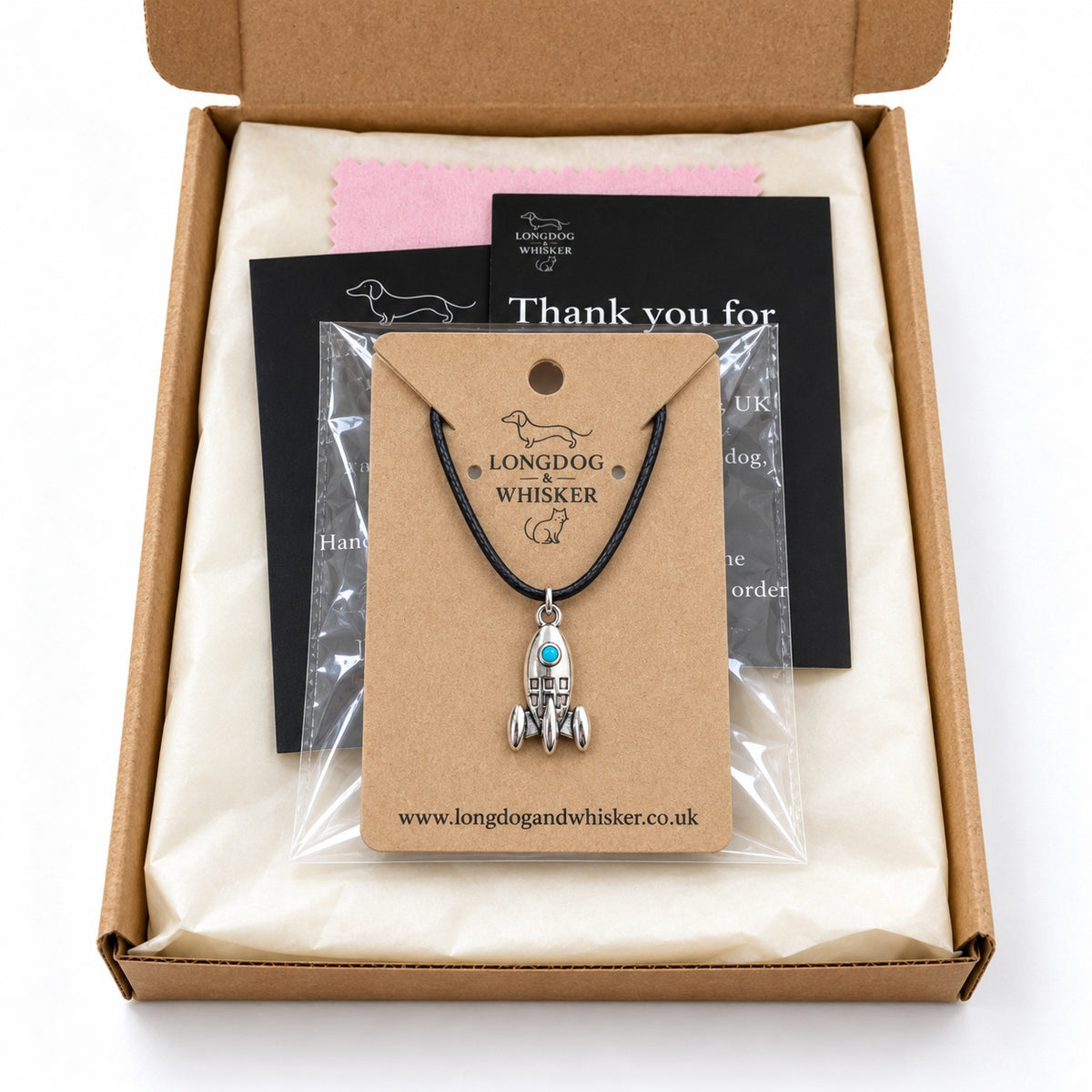 Turquoise porthole rocket necklace on its product card in gift-ready packaging