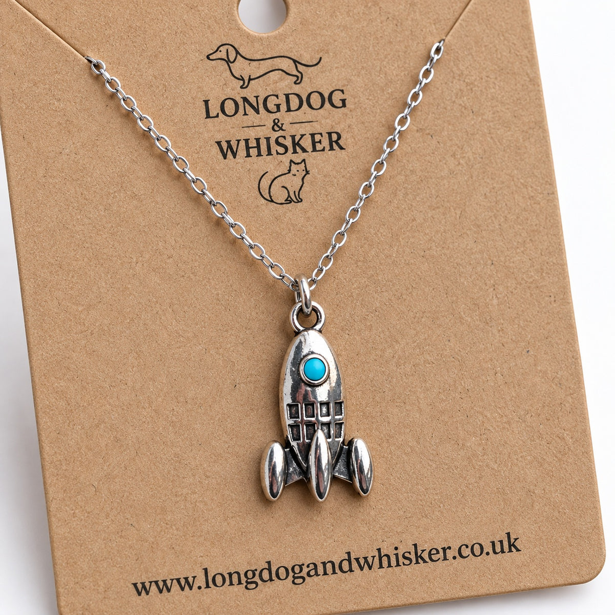 Close-up of the turquoise porthole, rocket fins and silver-tone chain connection