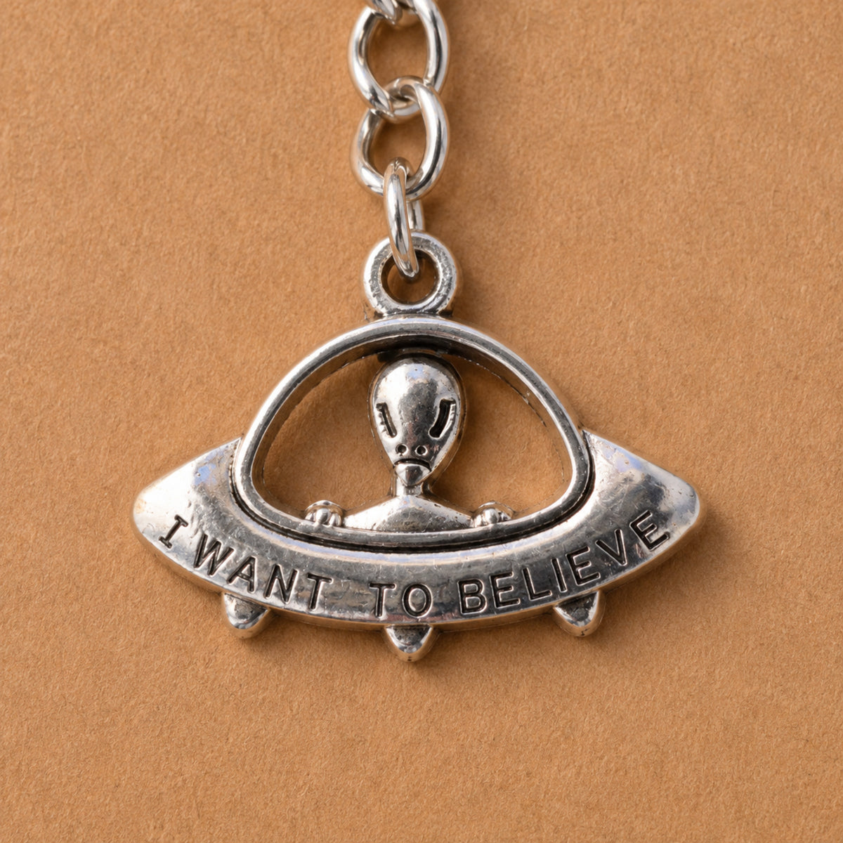 Close up of silver UFO Believe Keyring and Bag Charm