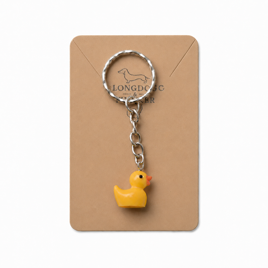 Yellow duck keyring and bag charm with silver-tone ring and chain on a Longdog & Whisker display card