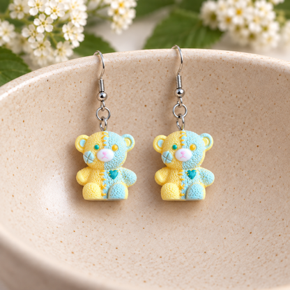 Yellow Pastel Patchwork Bear Earrings hanging in ceramic bowl lifestyle scene