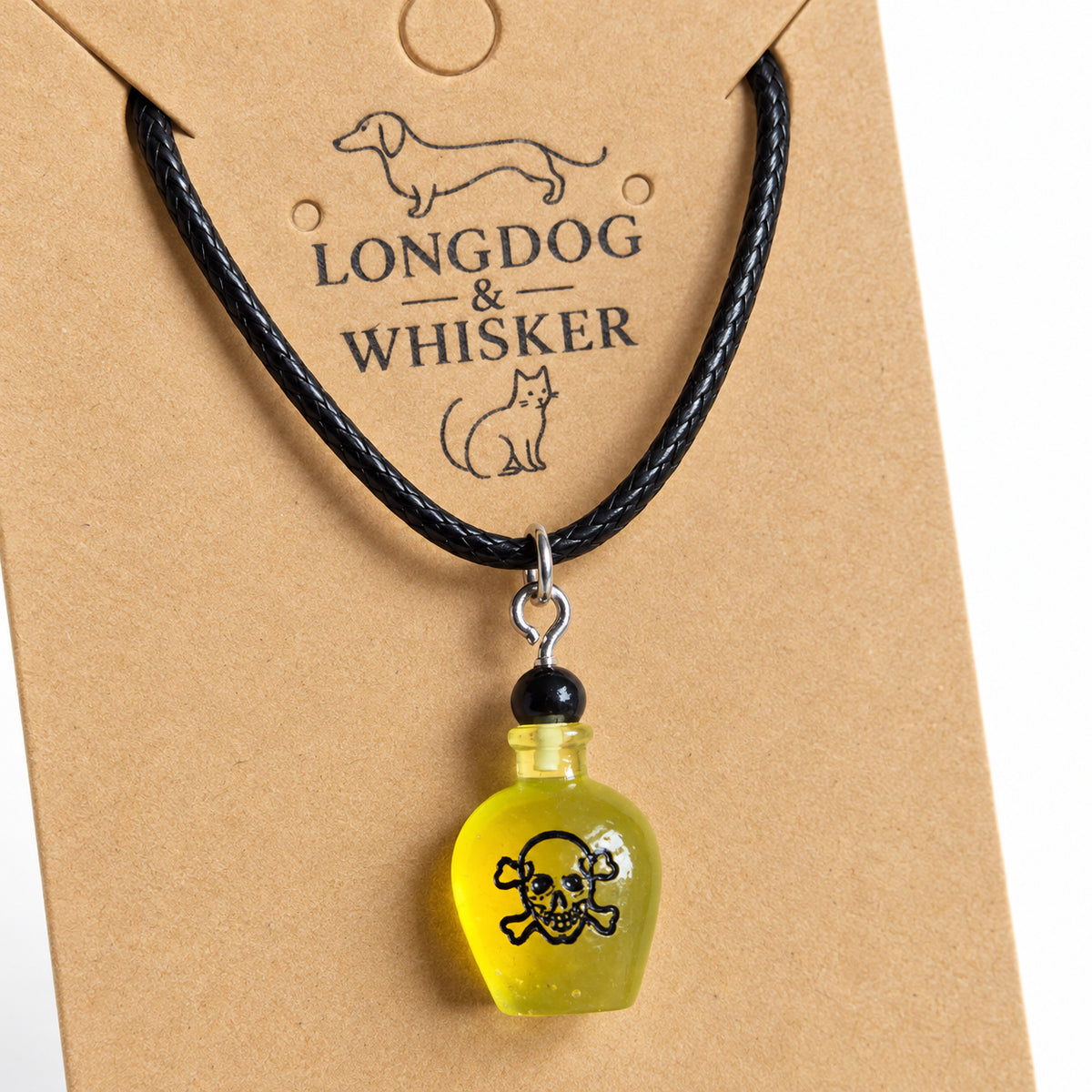 Close-up of the yellow poison bottle pendant, black skull design and silver-tone connectors on black cord.